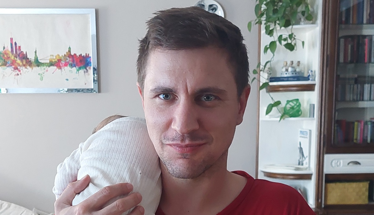 Papa mit Baby auf dem Arm als Symbol für Mental Load und geteilte Verantwortung