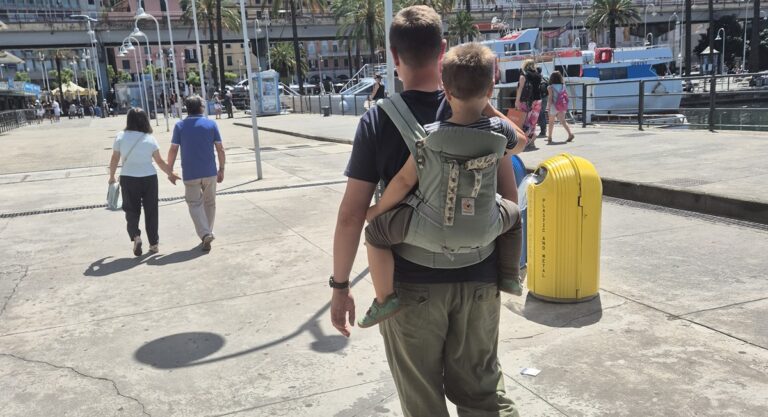 Papa trägt sein Kind in einer Babytrage auf dem Rücken