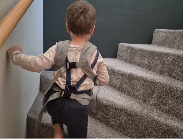 Kind steigt selbstständig eine Treppe hinauf – weniger Spielzeug und mehr Raum für Bewegung und eigene Erfahrungen.